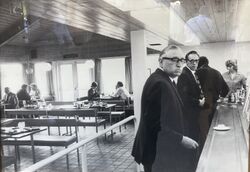 Two men queuing at a buffet counter.