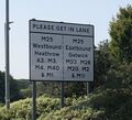 A road sign saying "please get in lane".